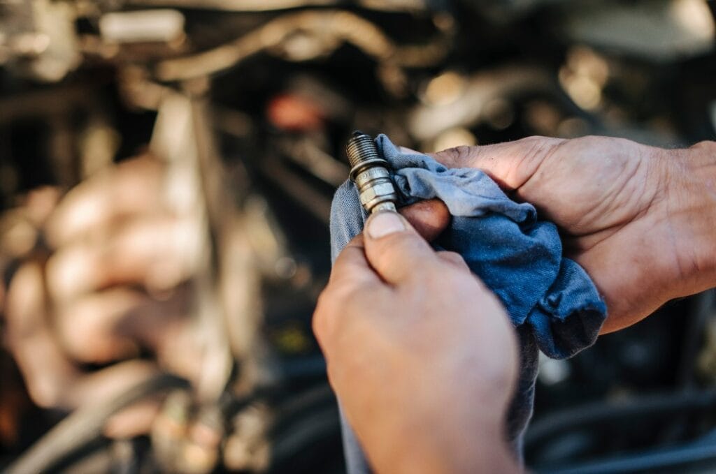 Man checks the spark plug on the old car